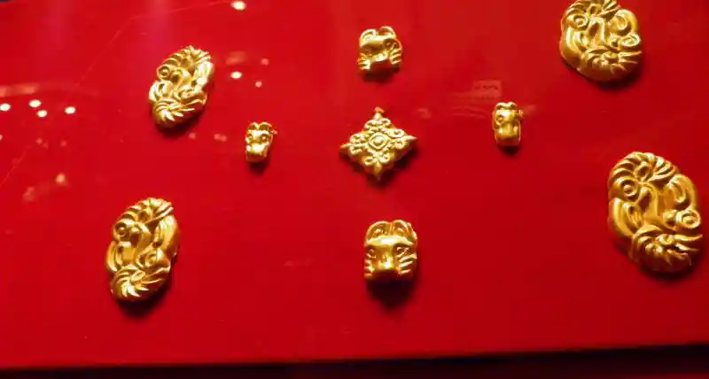 Gold jewelry in the form of a cross that resembles a fleur-de-lis